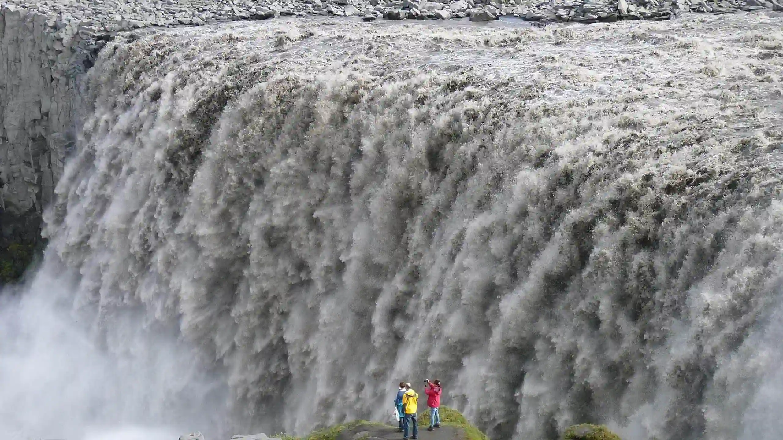 North Iceland travel guide photo of Dettifoss waterfall with visitors standing at the viewpoint near the powerful cascade