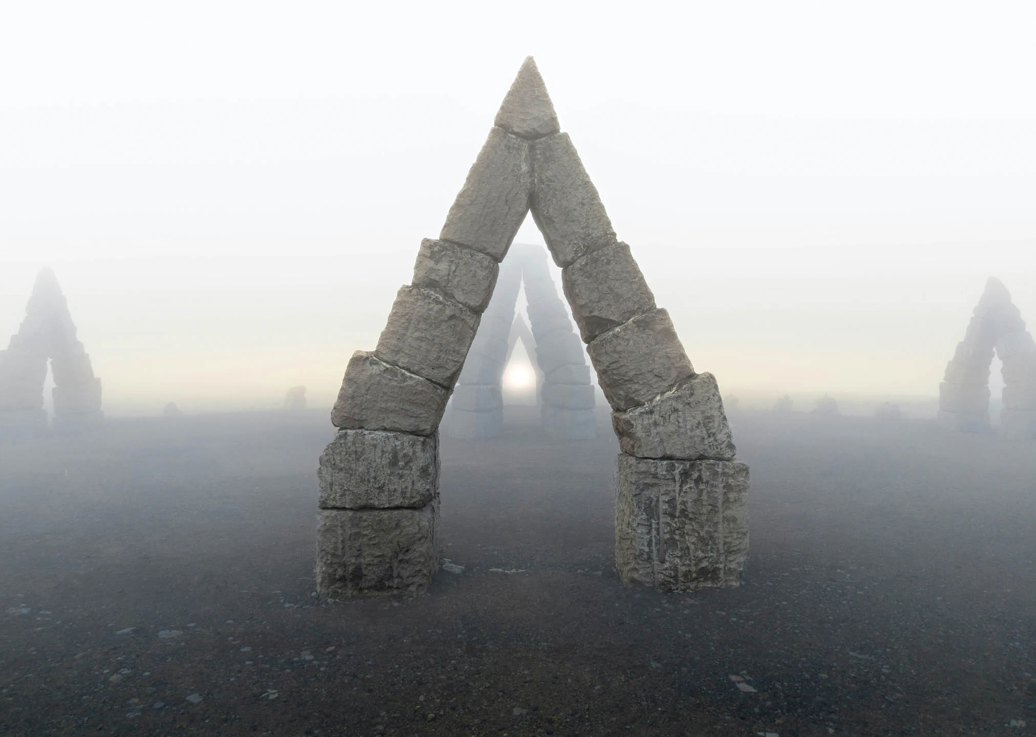 Fog covered Arctic Henge Iceland stone arch rising from a barren volcanic landscape with multiple stone triangles fading into the mist.