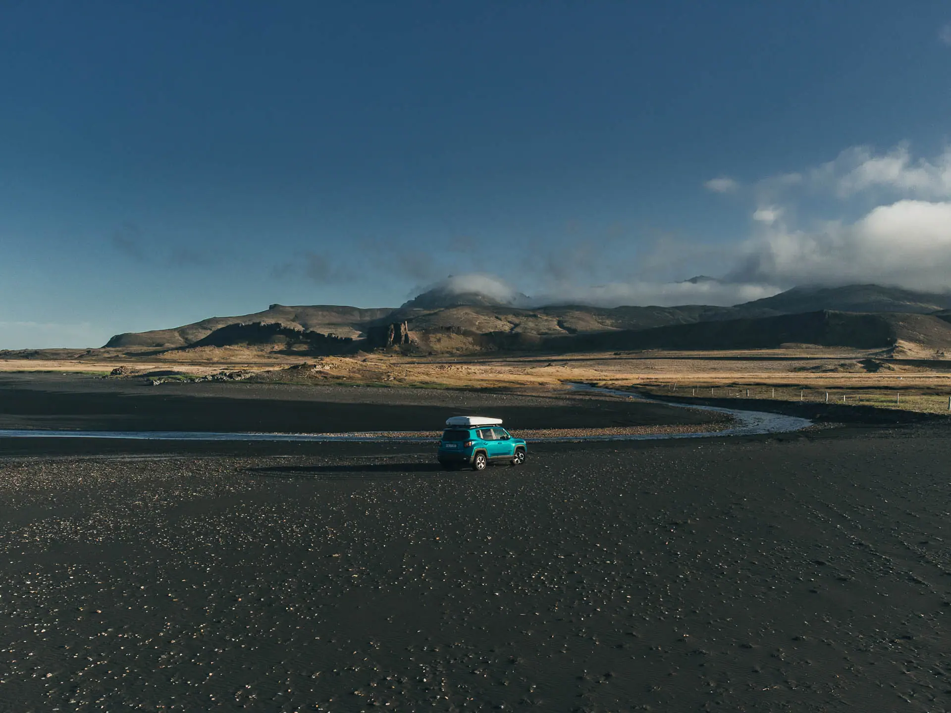 4x4 camper rental parked on a black sand plain in Iceland during a Highland driving trip