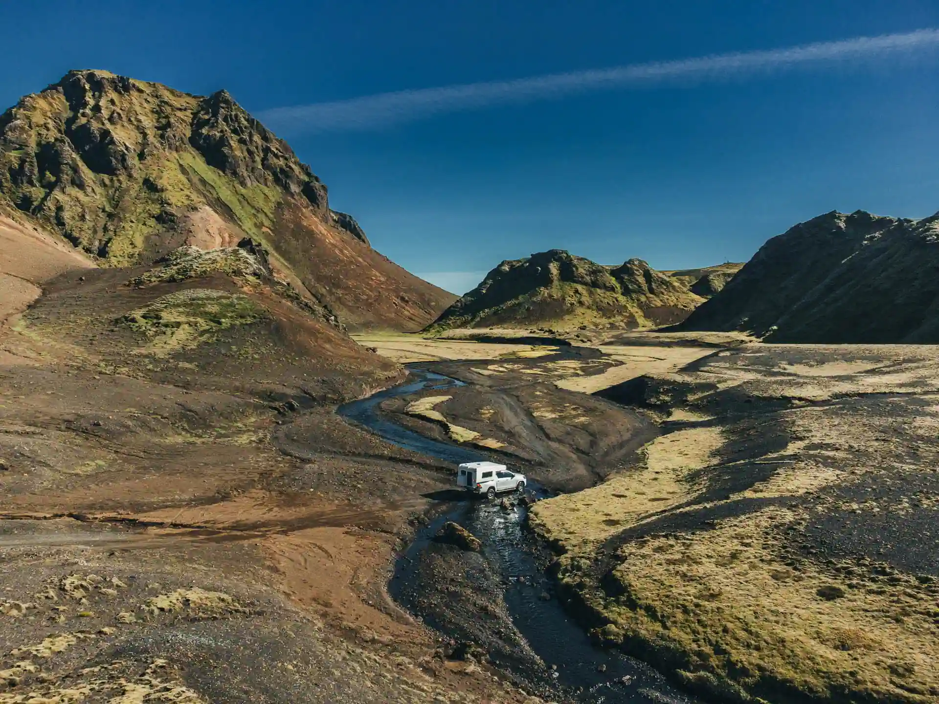 4x4 campervan crossing a shallow Icelandic river in the Highlands, showing proper technique for safe river crossings.