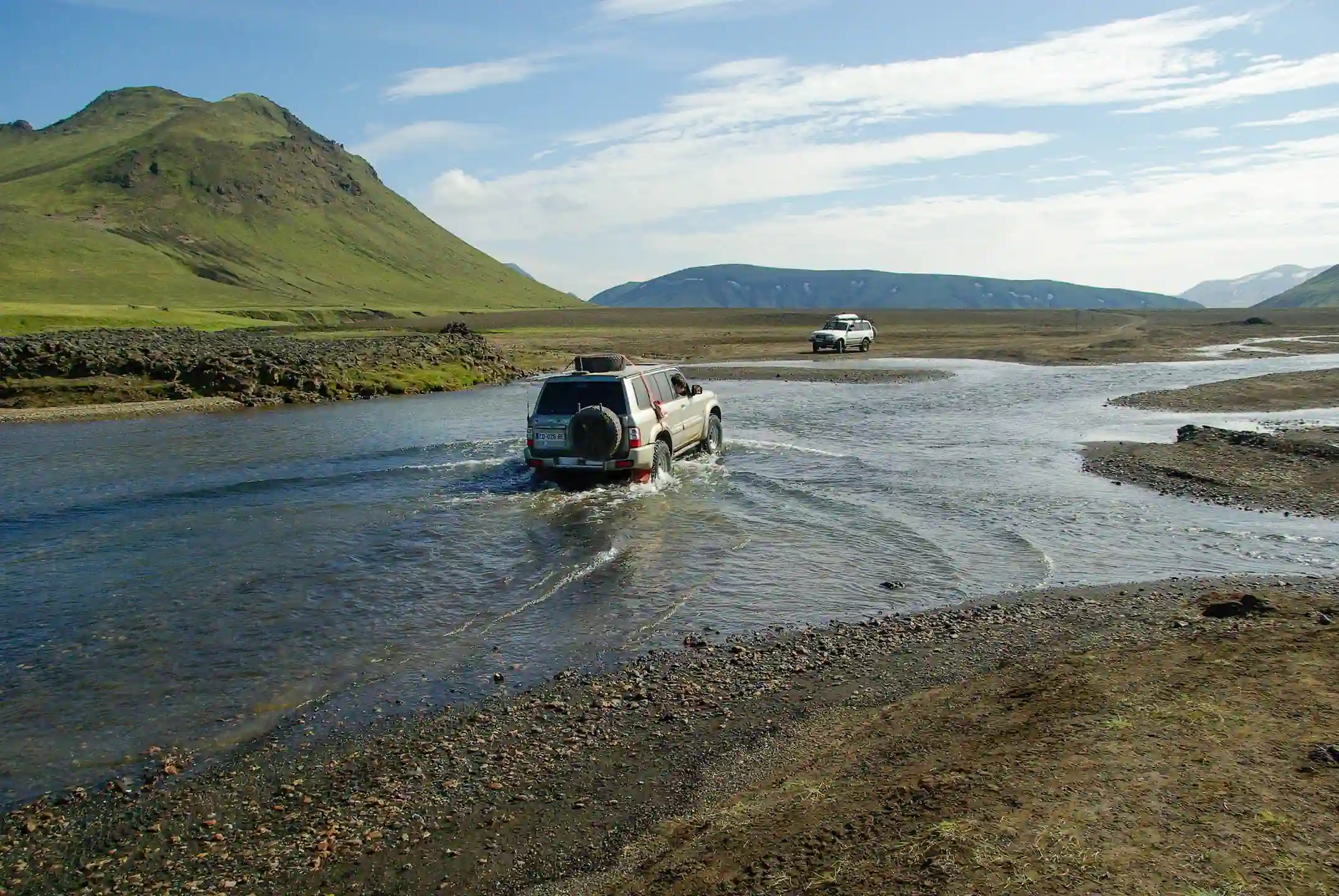 4x4 vehicle safely driving through a shallow river on an Icelandic F-road, showing the correct way to cross rivers in Iceland during Highland travel.