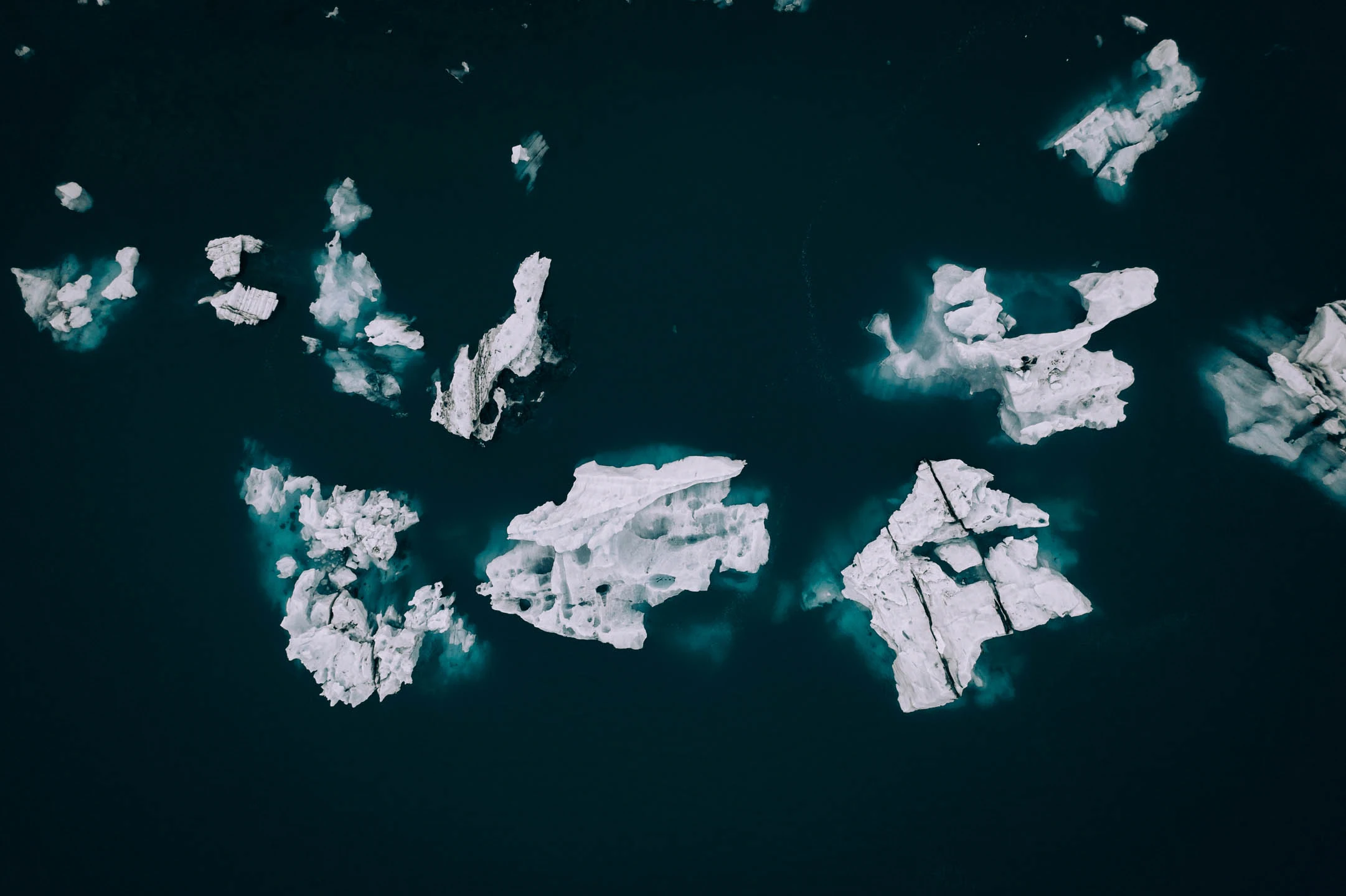 Aerial view of floating icebergs in a dark glacial lagoon in Iceland during a scenic campervan journey
