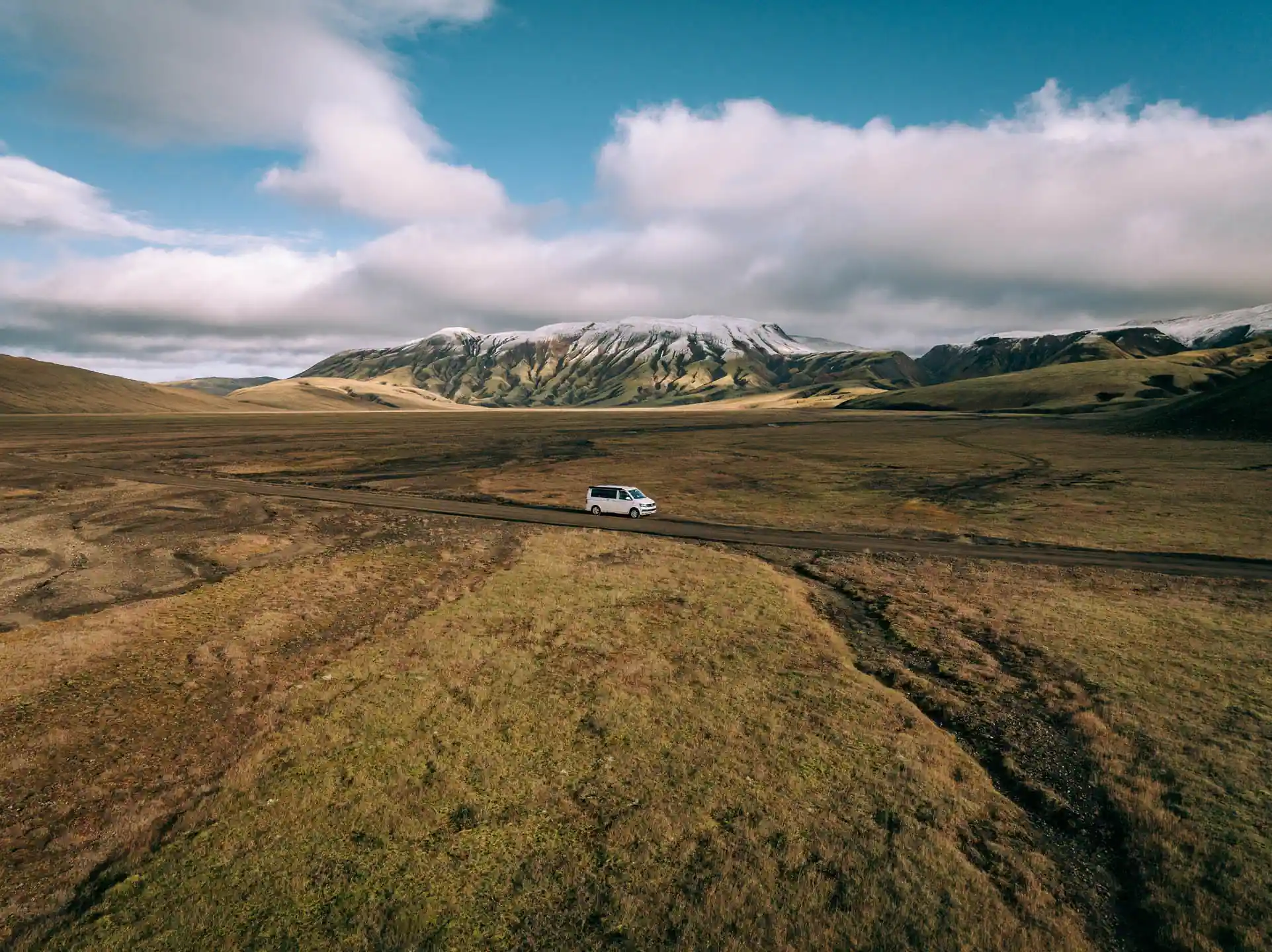 campervan driving in Icelandic mountain roads with mountains in backround