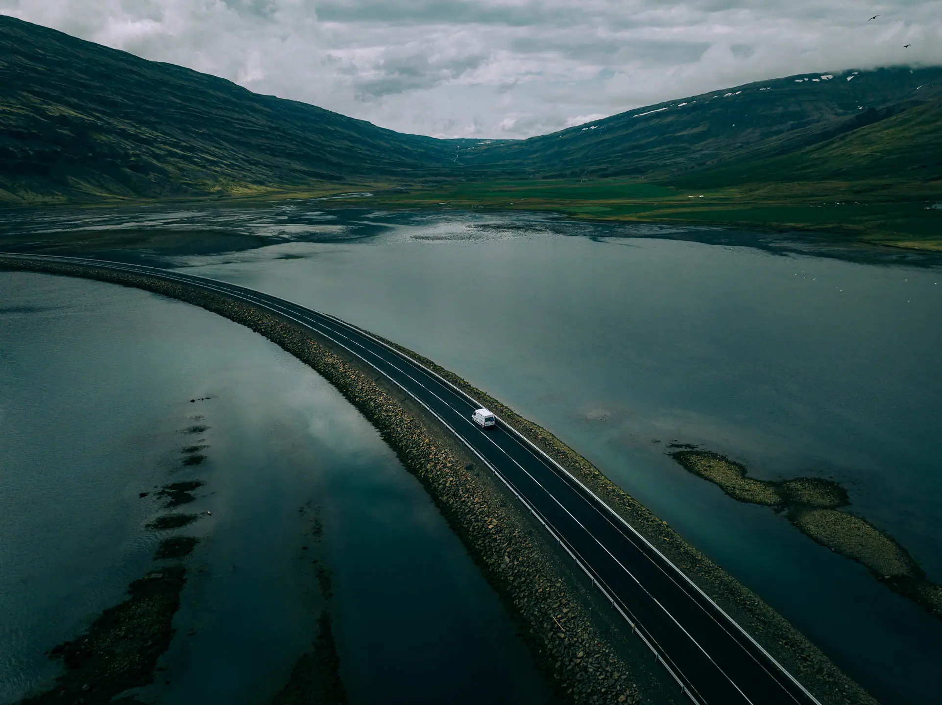 campervan driving along the Ring Road in Iceland through fjord landscape during an Iceland campervan road trip